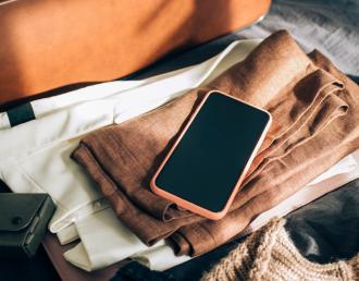 smartphone sitting atop luggage