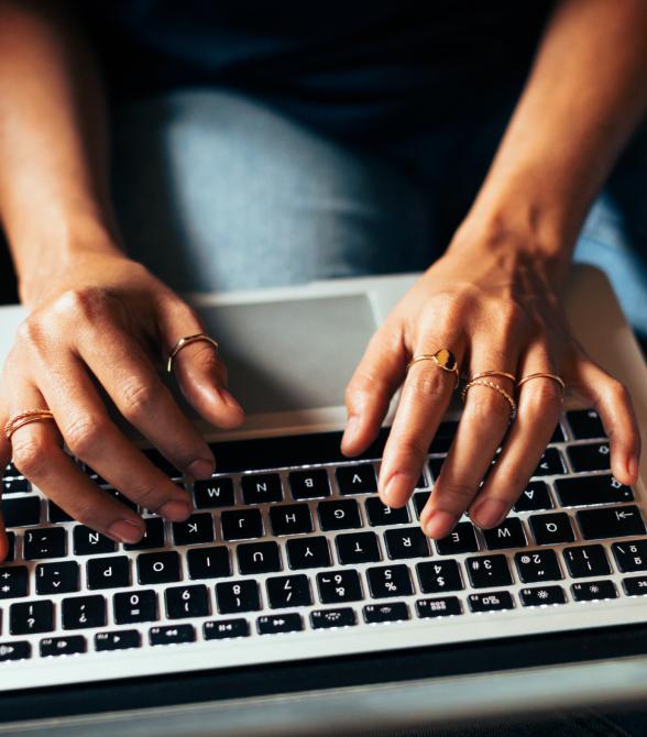 close up of hands typing on laptop